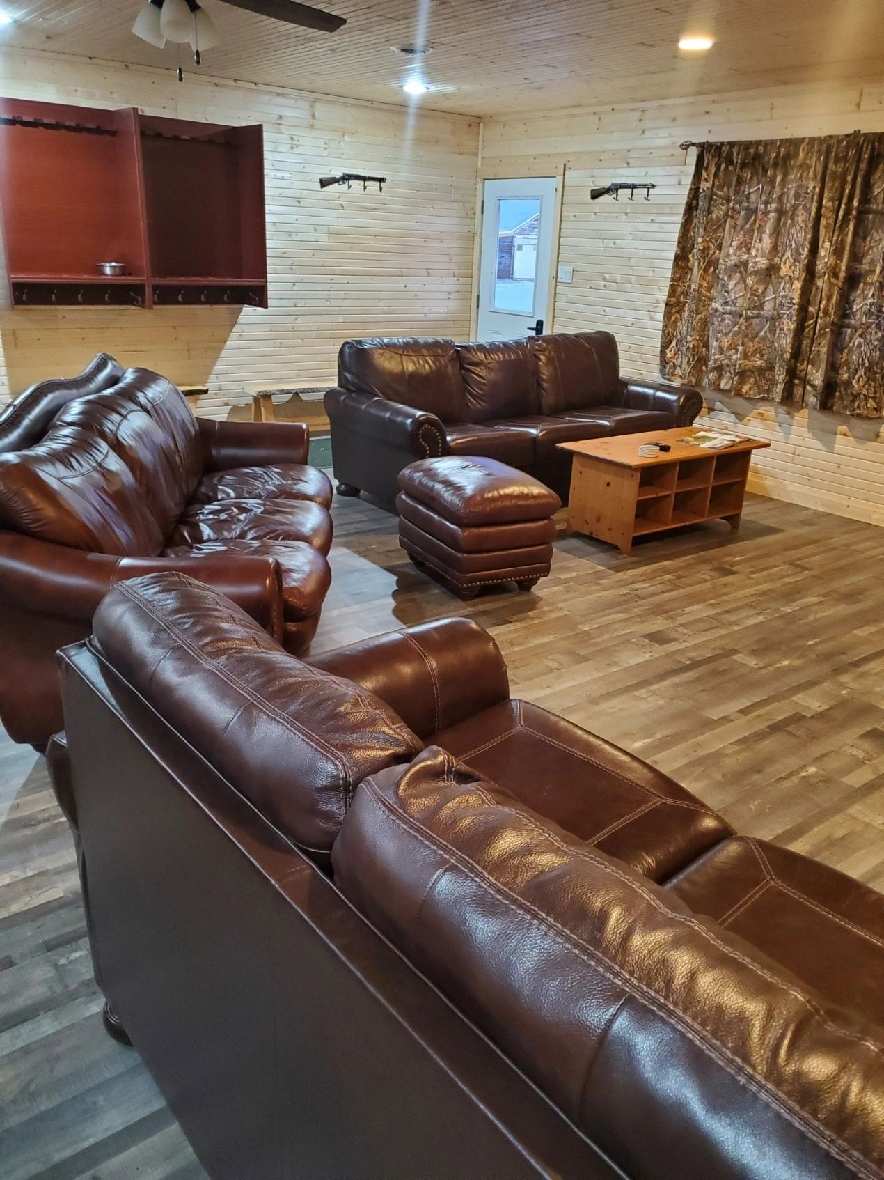 Guest cabin lounge with leather sofas at Coteau View Hunts in Conde, SD