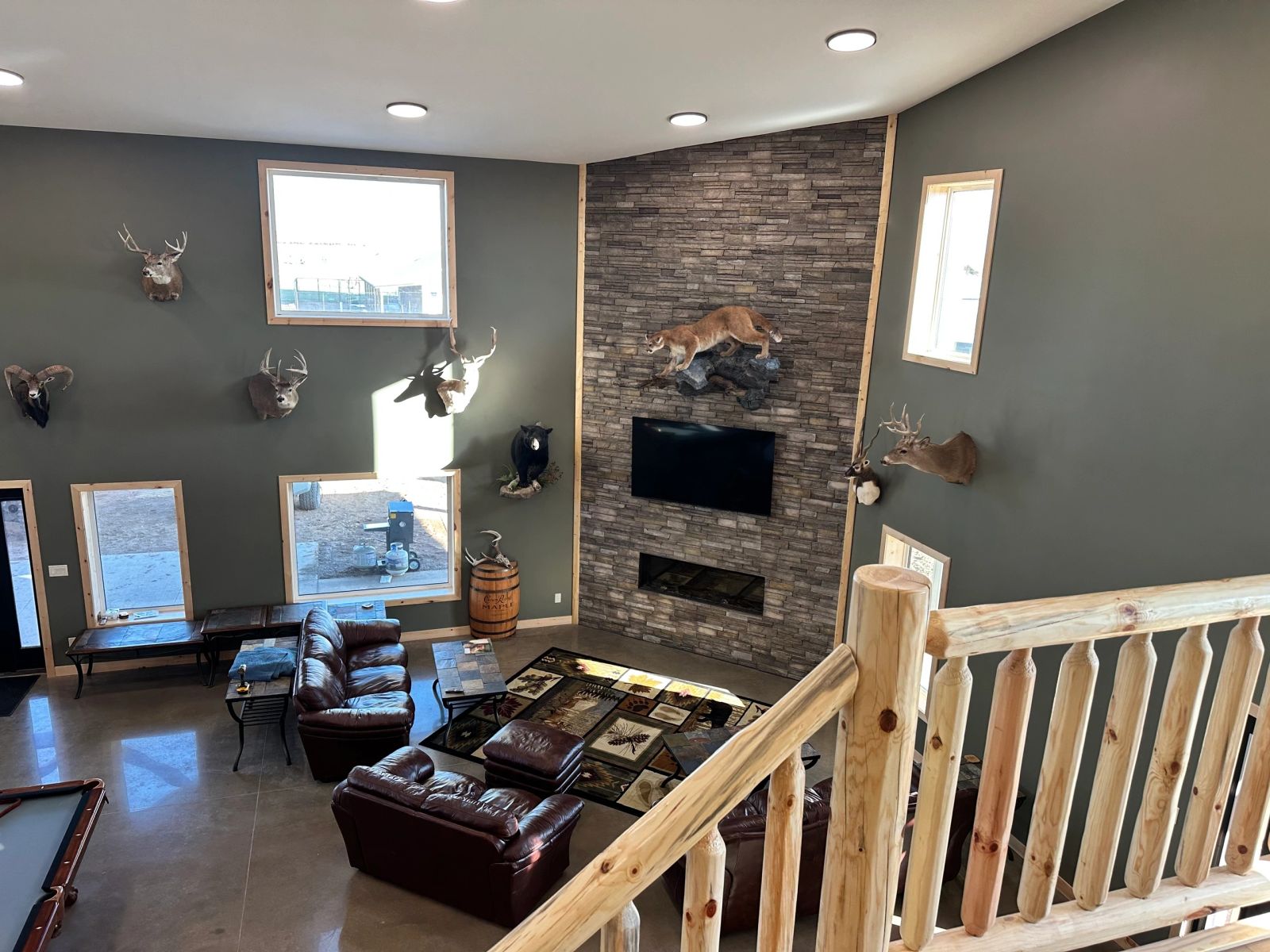 Stone fireplace lounge with leather seating in the South Dakota hunting lodge
